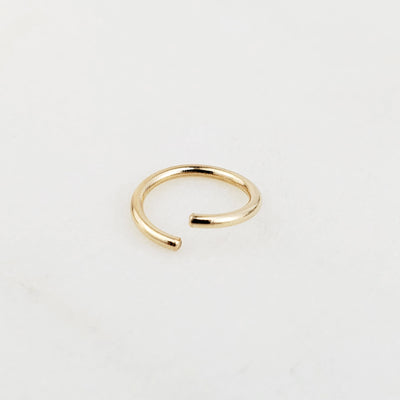 14k yellow gold nose ring on white background